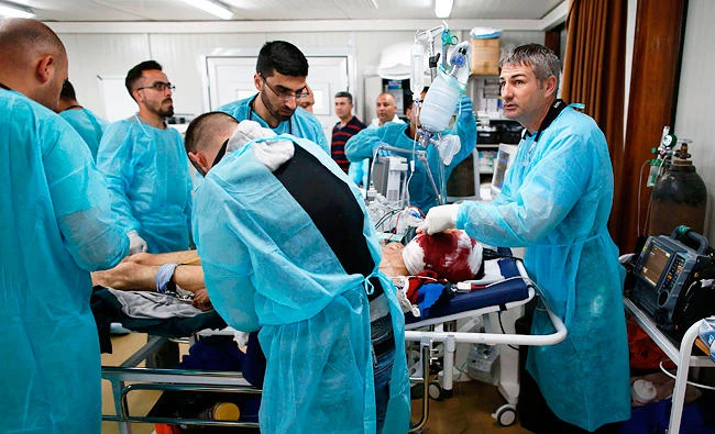Medics treat a civilian who was injured during the ongoing conflict between government forces and Daesh. (AFP)