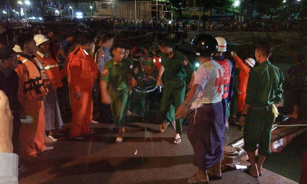 This photo taken on April 7, 2017 shows Myanmar soldiers and members of a rescue team carrying the body of a ferry passenger after the ship sank in the Nga Wun River in Pathein, a port city west of the commercial capital Yangon. (AFP)