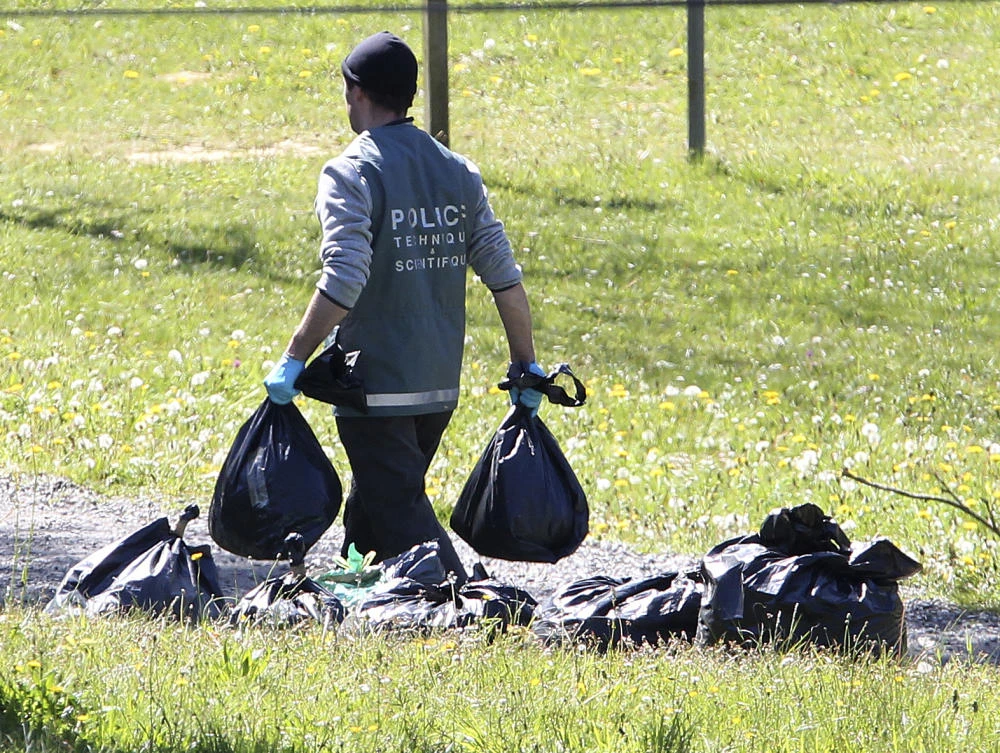 A French police officer collects plastic bags at a hideout used by Basque separatist guerrillas ETA in southwestern France. (AP)