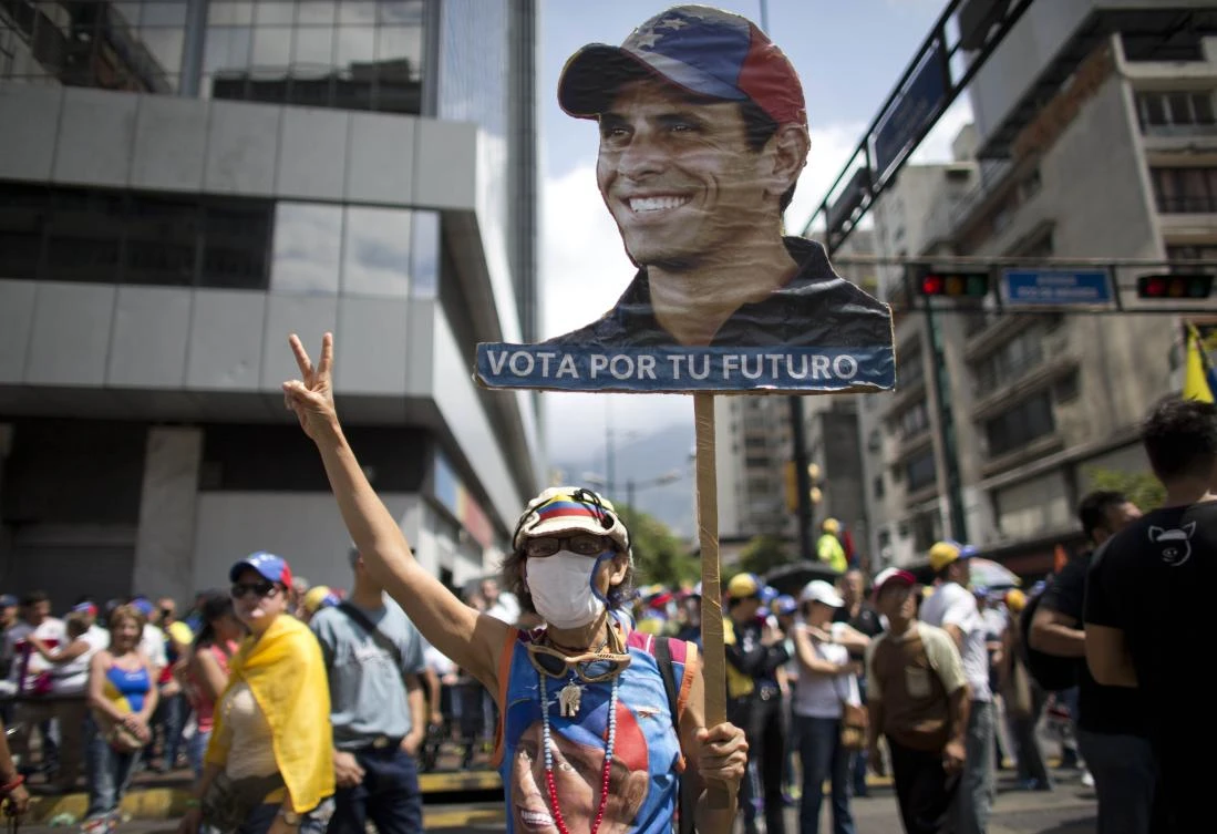 A woman holds up a banner with the image of Venezuelan opposition leader Henrique Capriles. (AP)