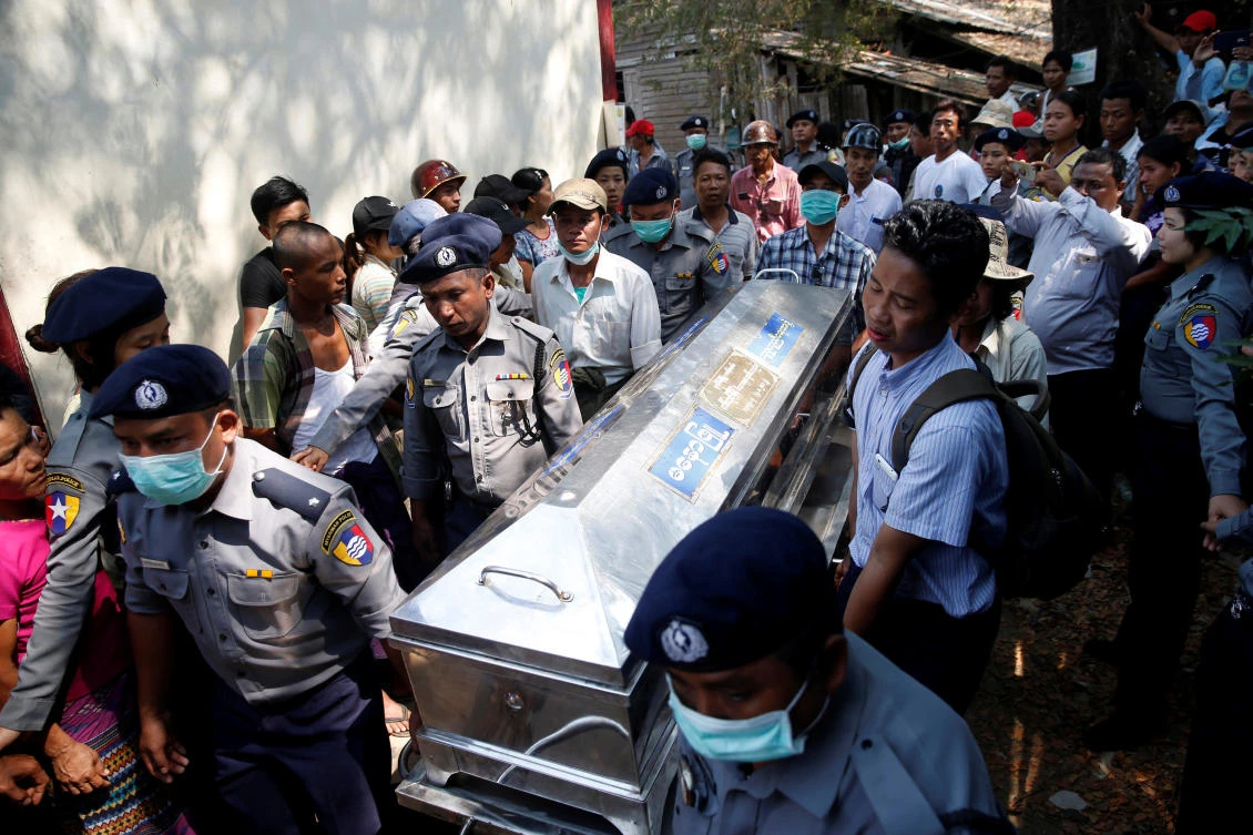 Police carry a victim's body at Pathein General Hospital after a boat with 60 passengers capsized in Pathein river, Myanmar. (Reuters)