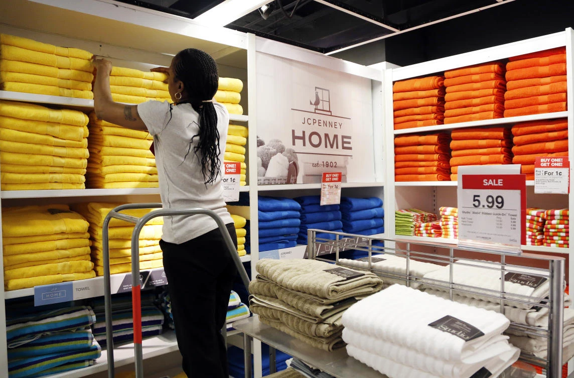 A sales clerk arranges towels that are part of a "Buy One Get One for a Penny" sale at a J.C. Penney store, in New York. (AP)