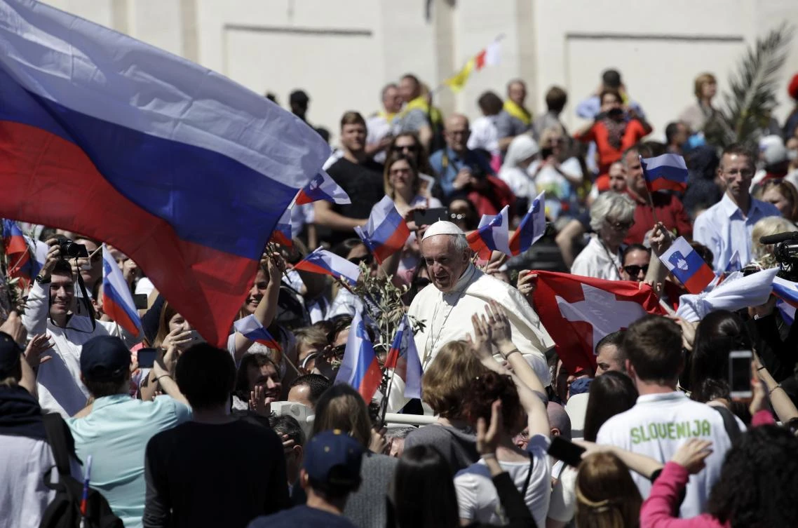 Pope Francis waves to the crowd past a Slovenian flag after celebrating a Palm Sunday Mass in St. Peter’s Square at the Vatican, Sunday, April 9, 2017. (AP)