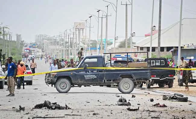 Somalian security forces and residents gather at the scene of a suicide car attack near the Defense Ministry in Mogadishu on Sunday. (AFP)