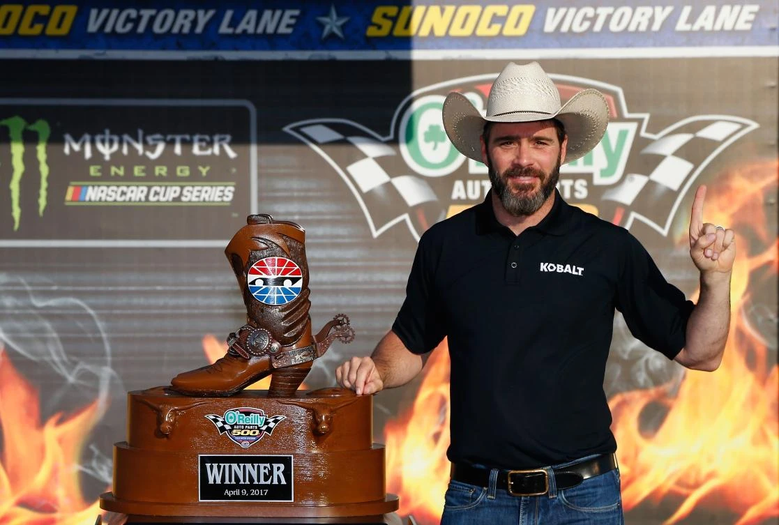 Jimmie Johnson, driver of the #48 Lowe's Chevrolet, with the trophy in Victory Lane after winning the Monster Energy NASCAR Cup Series O'Reilly Auto Parts 500 at Texas Motor Speedway on Sunday in Fort Worth, Texas. (AFP)