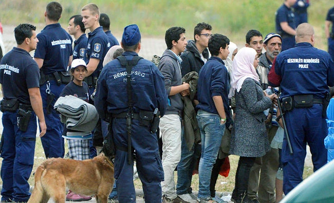 File photo: Asylum-seekers waiting to board a bus at the Hungarian-Serbian border to transport them to a new refugee camp. (AFP)
