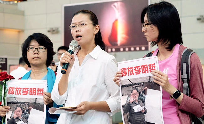 Li Ching-yu, center, wife of Taiwanese pro-democracy activist Li Ming-che detained in China, holds a press conference. (AP)