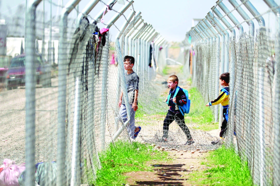 A displaced Iraqi boy who fled his home with his family carries a school bag at Khazer camp, in this file photo. (Reuters)