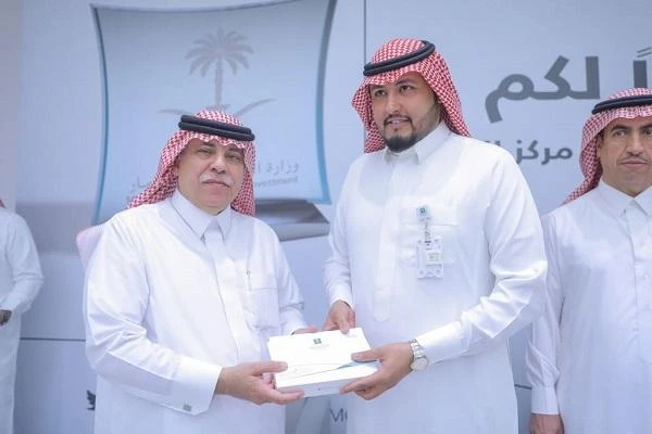 Commerce and Industry Minister Majid Al-Qassabi, left, presents a token to one of the inspectors who were commended for their efforts to control commercial fraud. (AN photo)