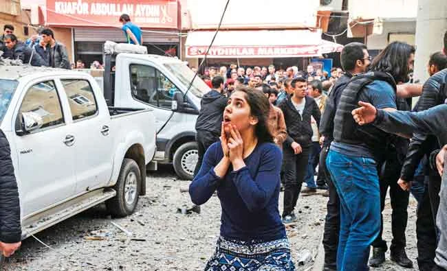 A woman reacts as she looks at the site of a strong blast near the riot police headquarters in the center of Diyarbakir, southeastern Turkey, on Tuesday. (AFP)
