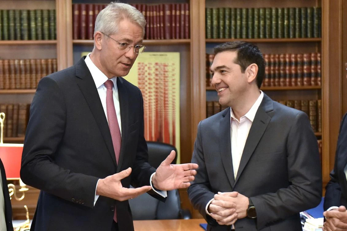 Greek Prime Minister Alexis Tsipras (R) talks with CEO of German airport operator Fraport AG Stefan Schultz. (AFP)
