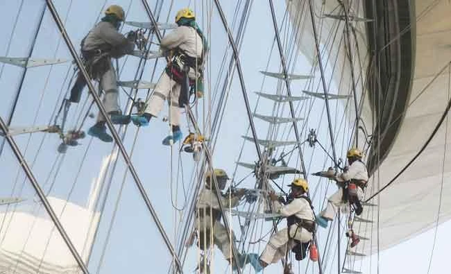 In this Sept. 19, 2016 file photo, workers hang from a building as they do the final elevation fixtures in Dubai, United Arab Emirates. (AP)