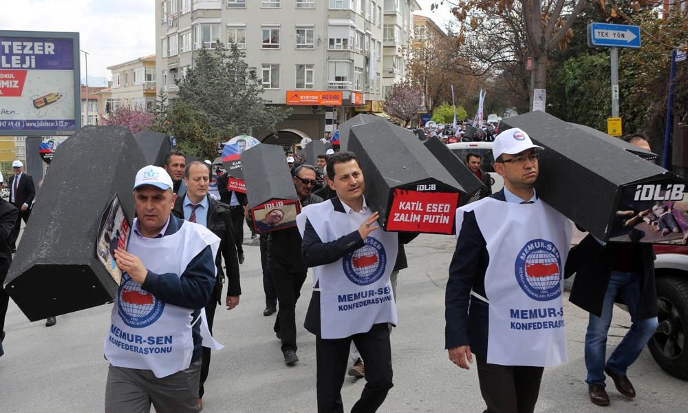 Men carry symbolic coffins with pictures of Syrian victims and inscriptions which translates as "killer Asad" and "killer Putin" during a protest against Russia for its alleged role in a chemical attack in the Syrian province of Idlib, on April 7, 2017 in Ankara, Turkey. (AFP file photo)