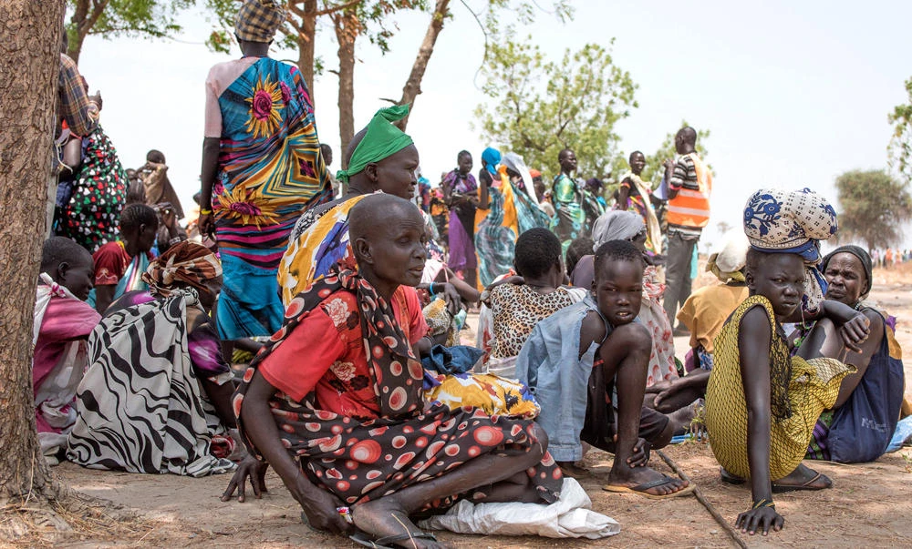 In this April 11, 2017 file photo, women wait to receive food by ICRC at a site in Leer County region of South Sudan. (AP Photo/File)