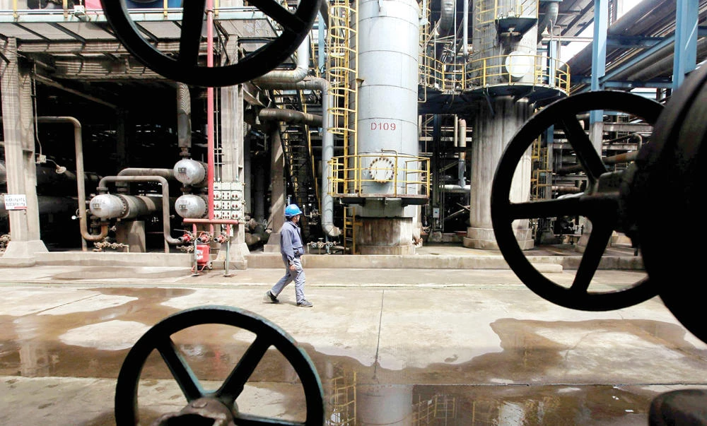 A worker walks past oil pipes at a Chinese refinery in Wuhan, Hubei province. (Reuters)