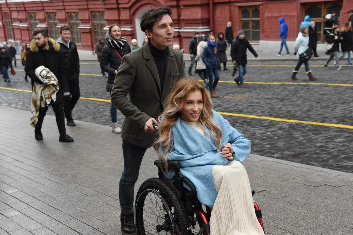 Russian singer Yuliya Samoilova is pushed in a wheelchair by her husband in Moscow on April 2, 2017. (AFP)