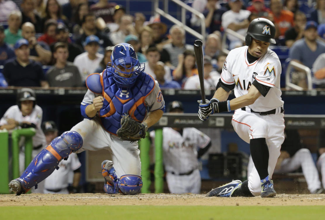 Miami Marlins' Ichiro Suzuki, right, strikes out swinging next to New York Mets catcher Travis d'Arnaud during the seventh inning of a baseball game in Miami on Thursday. (AP)