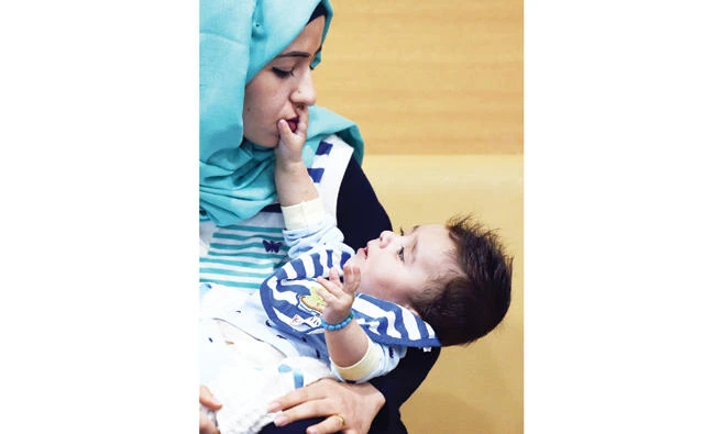 Iraqi mother holds her 7-month-old son Karam during a press conference at a hospital in Noida on Friday. (AFP)