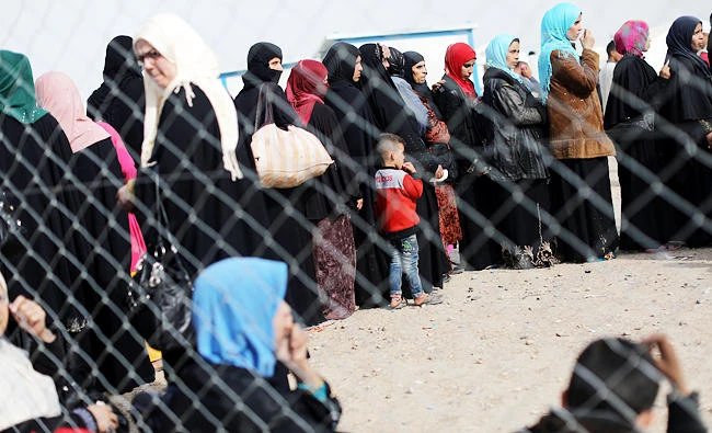 Displaced Iraqi women and children wait in line to enter Hammam al-Alil camp, south of Mosul, Iraq, in this April 8, 2017 photo. (REUTERS)