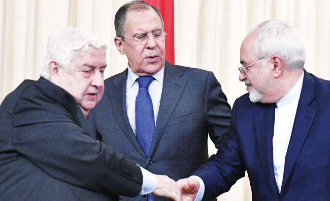 Iranian Foreign Minister Mohammed Javad Zarif, right, shakes hands with his Syrian counterpart Walid Muallem, left, as Russian Foreign Minister Sergei Lavrov looks on after a joint press conference in Moscow Friday. (AFP)