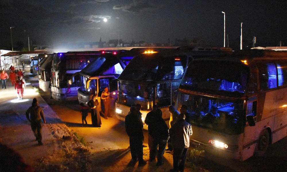 Militants and members of their families from Madaya and Zabadani board on buses heading to Ramousseh crossing in Aleppo, Syria, on April 14, 2017, as part of the deal between the opposition and the Syrian government. (AFP / George Ourfalian)