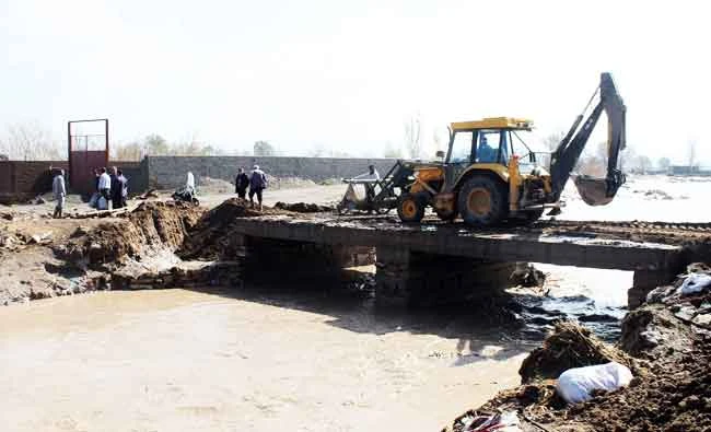 Workers trying to repair a damaged bridge over a river after torrential rains overflowed rivers and flooded houses, in the northestern Azarshahr city, south of Tabriz, Iran on Saturday. (AFP)