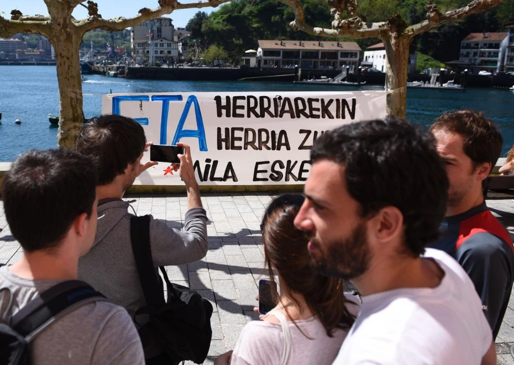A man takes a picture of a banner that reads in Basque "ETA with the people, the people with you. Thank you" in the northern Spanish Basque village of Pasaia on April 9, 2017. (AFP)