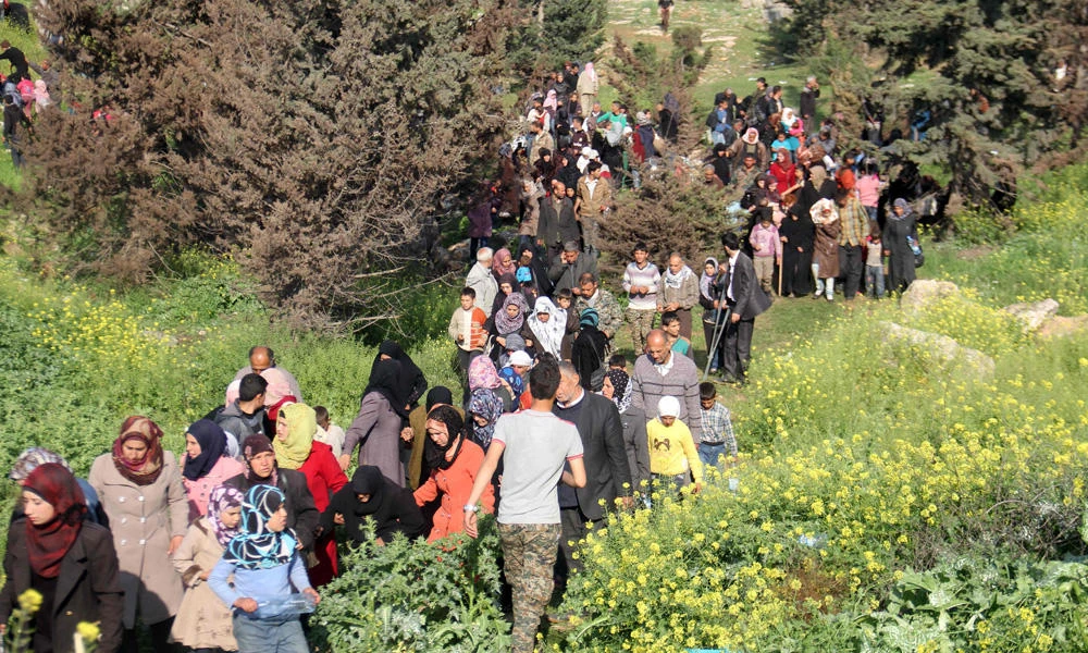 Syrians, evacuated from two besieged government-held towns of Fuaa and Kafraya, flee into a field near the site of a suicide car bombing that targeted their buses in Rashidin, west of Aleppo, on April 15, 2017. The evacuation was set to resume Sunday. (AFP / Omar haj kadour)