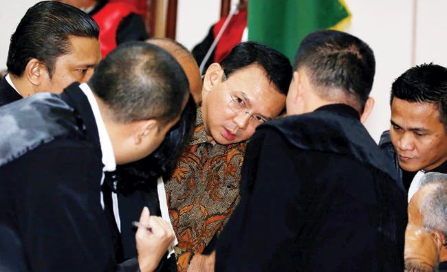 Jakarta Gov. Basuki Tjahaja Purnama talks to his lawyers during a recent court hearing in Indonesia. (Reuters)