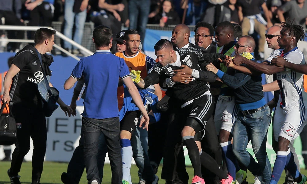 A security staff holds Lyon's goalkeeper Anthony Lopes (C) during scuffles at half-time between some of Lyon's players and Bastia supporters who invaded the pitch, during the French L1 football match Bastia (SCB) vs Lyon (OL) on Sunday in the Armand Cesari stadium in Bastia on the French Mediterranean island of Corsica. (AFP / PASCAL POCHARD-CASABIANCA)