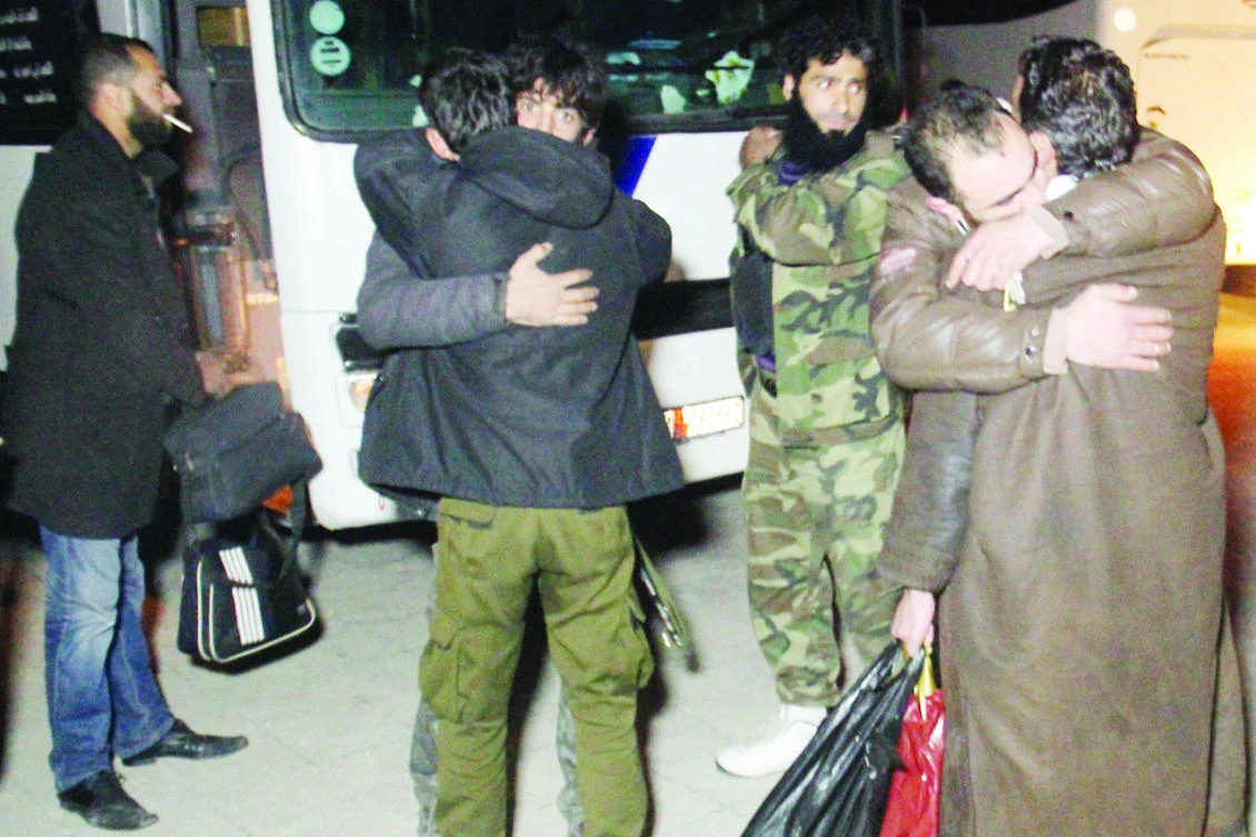 Syrians embrace relatives as buses transporting people evacuated from two besieged opposition-held towns of Madaya and Zabadani arrive in Idlib . (AFP)