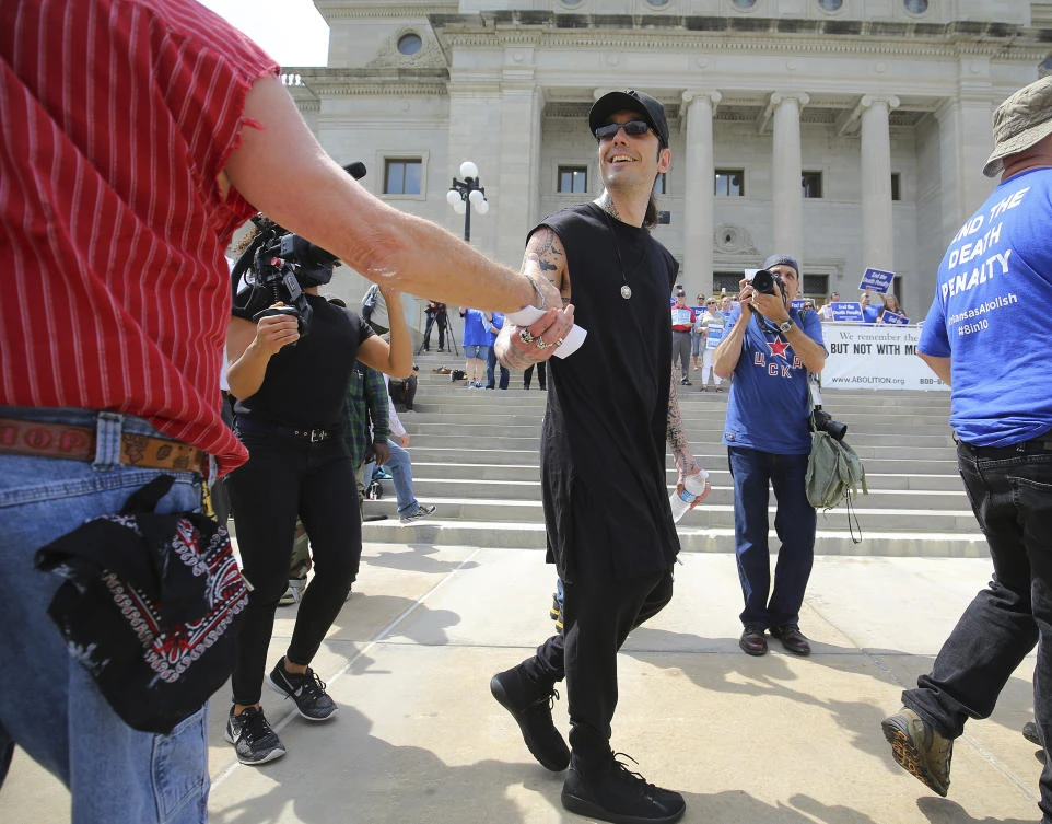 Former Arkansas death row inmate Damien Echols, center, acknowledges someone at a rally opposing the state's upcoming executions, on the front steps of Arkansas' Capitol. (The Arkansas Democrat-Gazette via AP)