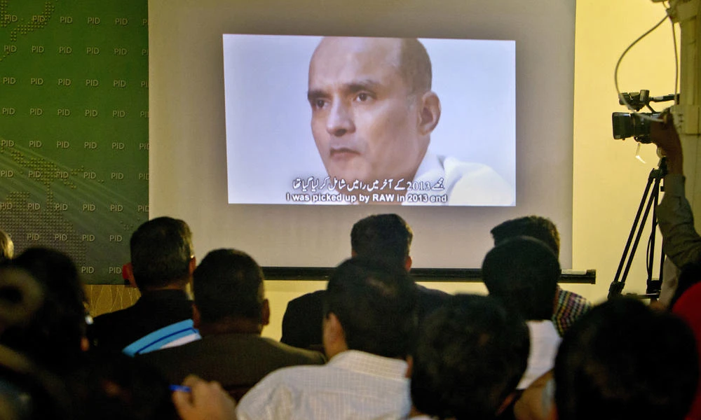 journalists look at A picture of Indian naval officer Kulbhushan Jadhav is shown during a press conference by Pakistan's army spokesman and the Information Minister in Islamabad, Pakistan, on IMarch 29, 2016 photo. (AP file photo)