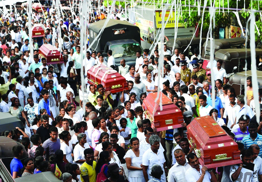 Sri Lankan families carry the coffins of victims who died following the collapse of a garbage dump in Colombo on Monday. (AFP)