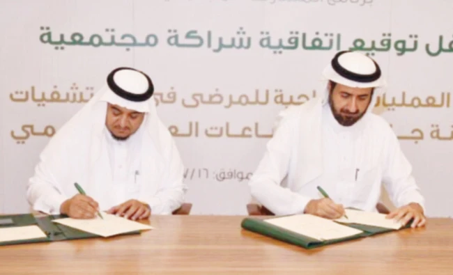 Health Minister Dr. Tawfiq Al-Rabiah, right, signs the agreement for community program in Riyadh on Sunday. (AN photo)