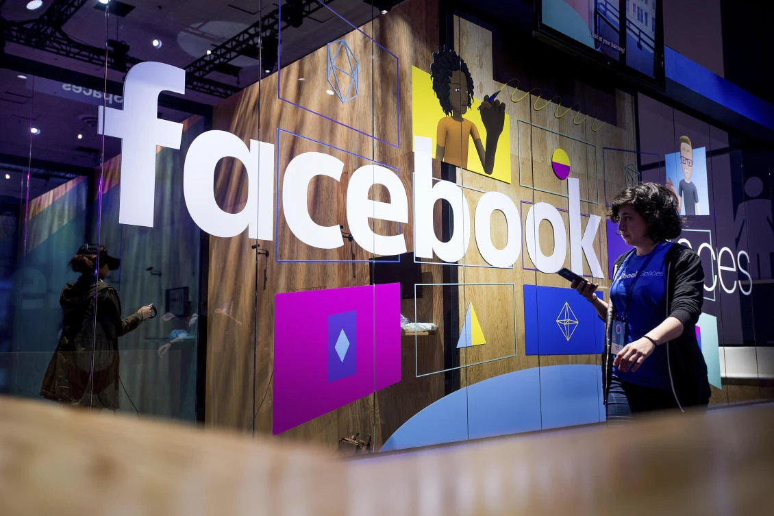 A conference worker passes a demo booth at Facebook's annual F8 developer conference, Tuesday, April 18, 2017, in San Jose, Calif. (AP)