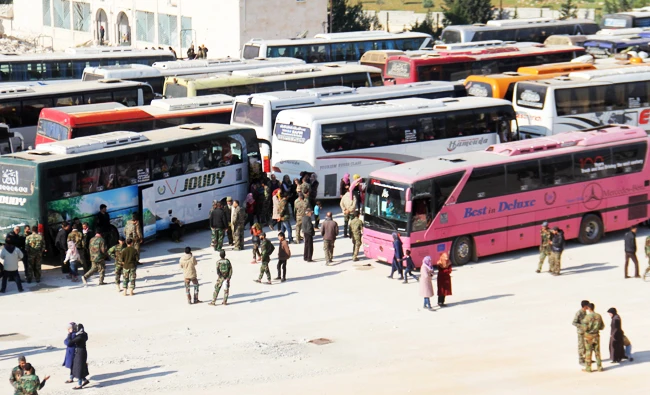 Syrian civilians and fighters from the government-held towns of Foua and Kafraya reach with buses the edge of the rebel-held transit point of Rashidin outside government-held second city Aleppo, on Wednesday. (AFP)