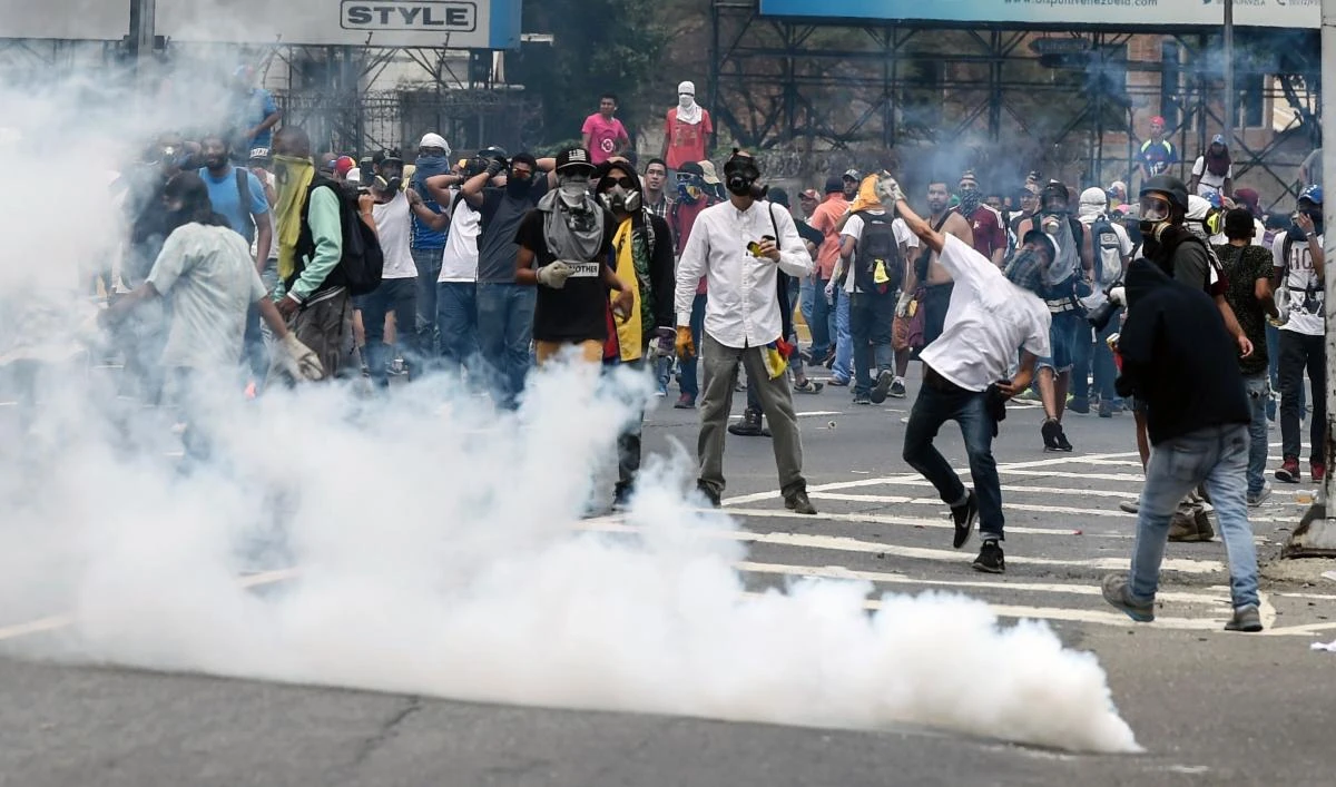 Demonstrators clash with the riot police during a protest against Venezuelan President Nicolas Maduro, in Caracas on Thursday. (AFP / JUAN BARRETO)