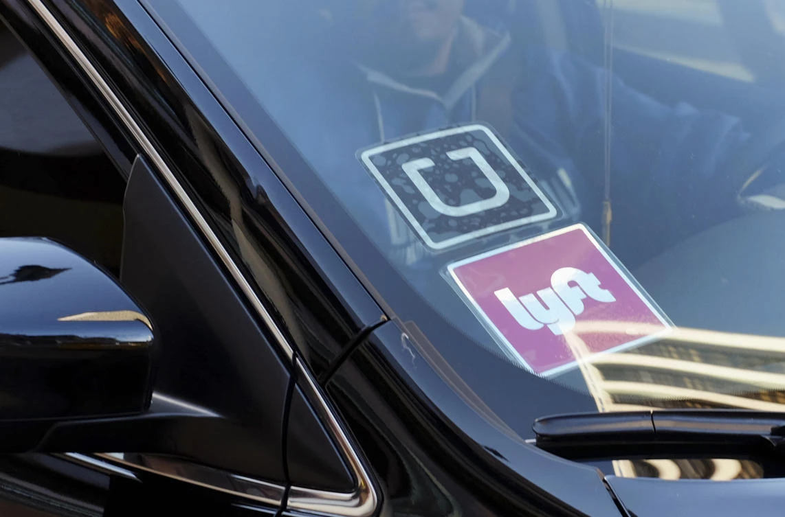 A driver displaying Lyft and Uber stickers. (AP)