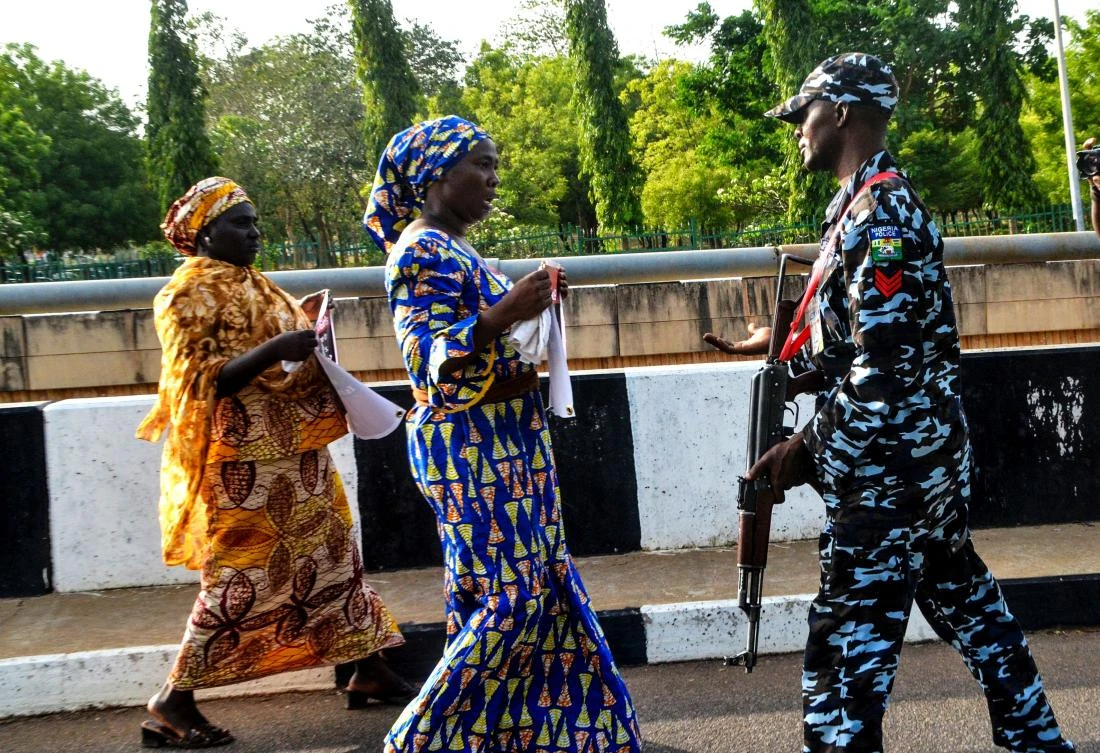 A Nigerian police officer blocks mothers of girls kidnapped by Boko Haram from marching on the Presidential Villa in Abuja. (AFP)