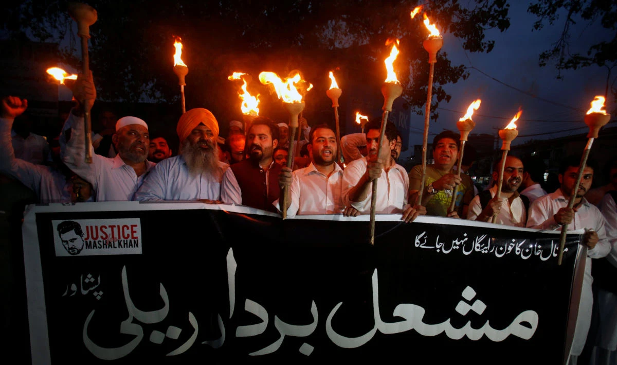 Protesters hold lamps to condemn the killing of Abdul Wali Khan university student Mashal Khan, after he was accused of blasphemy, during a protest in Peshawar, Pakistan, April 20, 2017. The banner reads, “We are all Mashal’s Brothers.” (REUTERS)