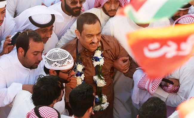 Supporters of Kuwaiti opposition leader Mussallam al-Barrak (c) celebrate his release from jail on Friday in Kuwait City, after serving two years in prison for insulting the emir. (AFP)