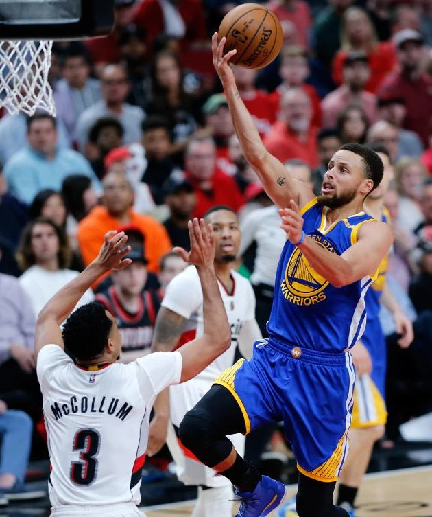 Golden State Warriors' Stephen Curry lays up the ball over CJ McCollum (3) of the Portland Trail Blazers during Game 3 of the Western Conference Quarterfinals of the 2017 NBA Playoffs at Moda Center on Saturday in Portland, Oregon. (AFP)