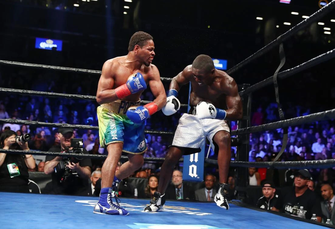 Shawn Porter knocks down Andre Berto in the ninth round during their WBC welterweight eliminator bout at the Barclays Center on Saturday in New York City. (AFP)