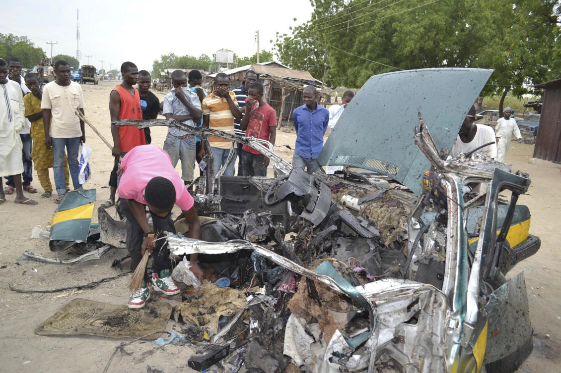 FILE- In this Oct. 12, 2016, file photo, people gathered at the scene of a suicide car bombed explosion in Maiduguri, Nigeria. (AP)