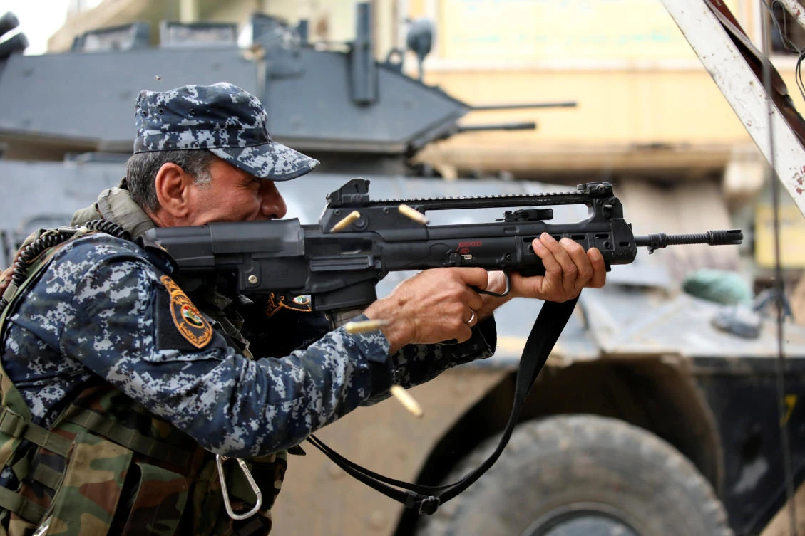 A member of the Iraqi Federal Police fires an assault rifle during combats against the Deash in western Mosul, Iraq. (REUTERS)