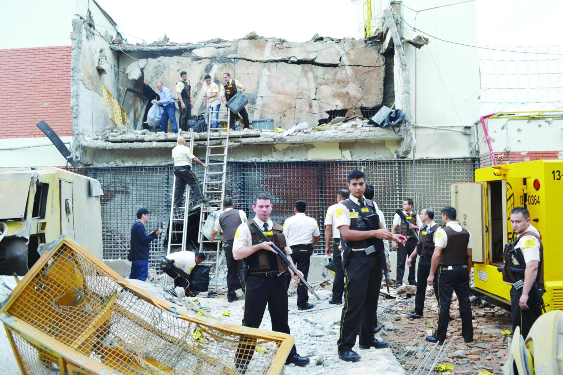 Guards and police inspect a vault that the assailants blew up in Ciudad del Este, Paraguay. (AP)