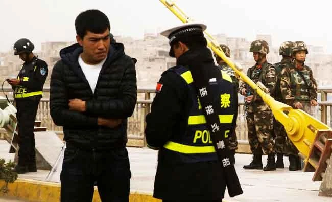 A police officer checks the identity card of a man as security forces keep watch in a street in Kashgar, Xinjiang Uighur Autonomous Region, China, in this photo taken on March 24, 2017. (REUTERS)