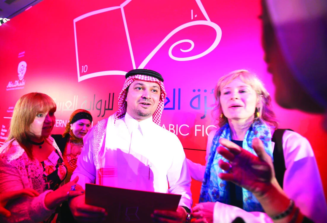 Saudi Arabian novelist Mohammed Hasan Alwan is surrounded by the journalists after he won the International Prize for Arabic Fiction (IPAF) in Abu Dhabi Tuesday. (AP)