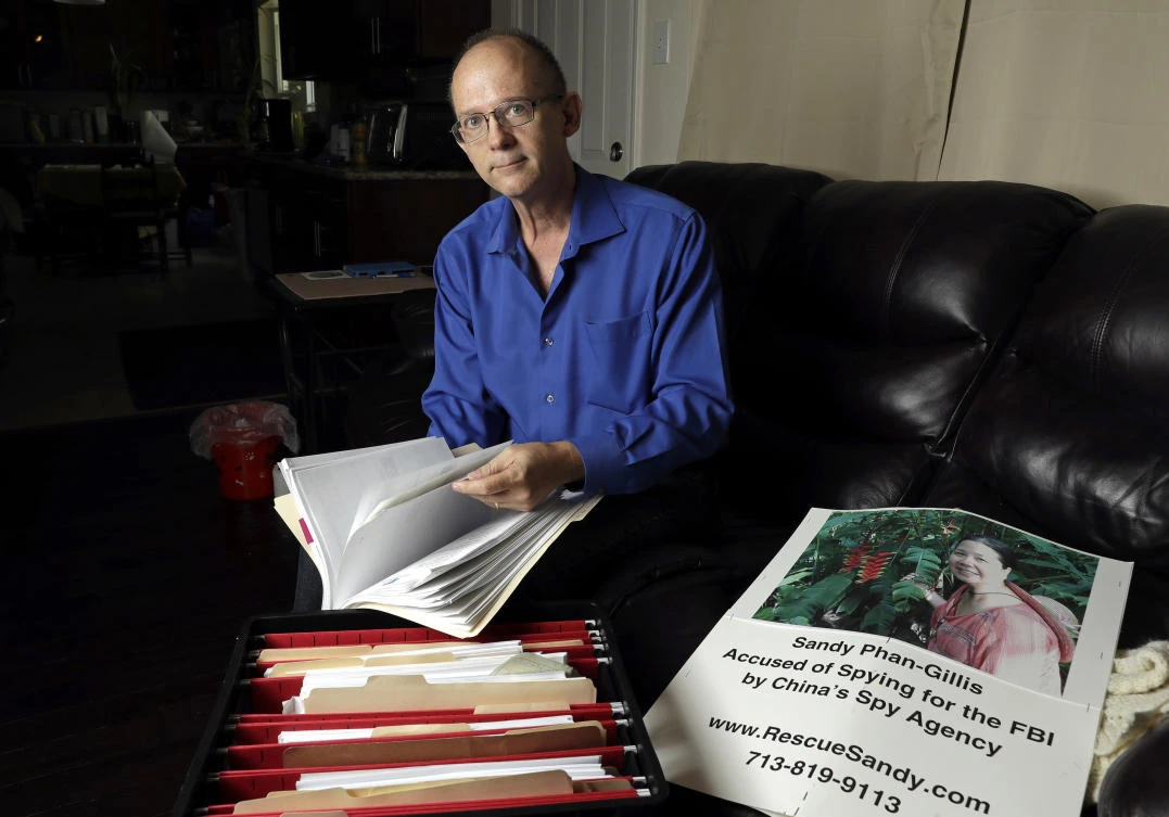 Jeff Gillis looks through documents he has collected in support of his wife in Houston. The husband of US citizen Phan “Sandy” Phan-Gillis, who has been charged in China with spying, has spent months trying to prove his wife’s innocence with the little information he had. (AP)